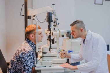 Genç güzel doktor/uzman/gözlükçü bir ophthalm içinde göz
