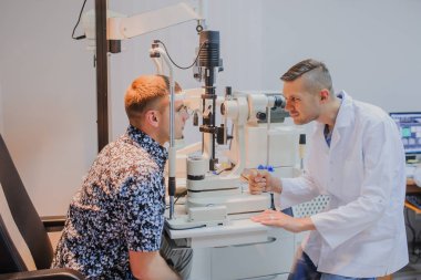 Genç güzel doktor/uzman/gözlükçü bir ophthalm içinde göz
