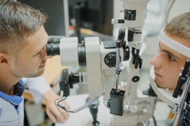 Genç güzel doktor/uzman/gözlükçü bir ophthalm içinde göz