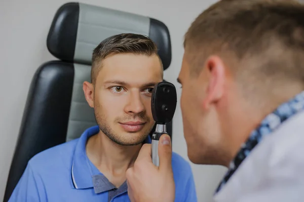 Genç güzel doktor/uzman/gözlükçü bir ophthalm içinde göz