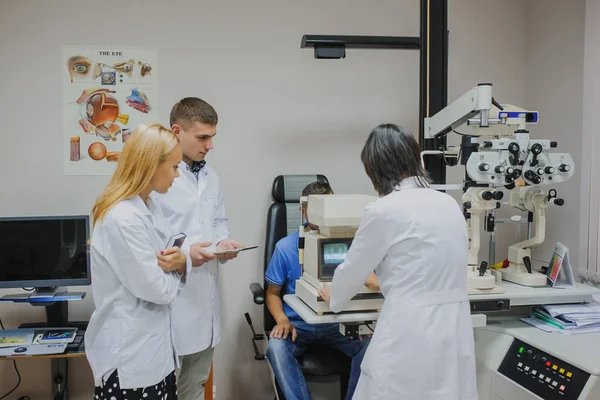 Médico ocular / optometrista / oftalmologista examinando um paciente jovem — Fotografia de Stock