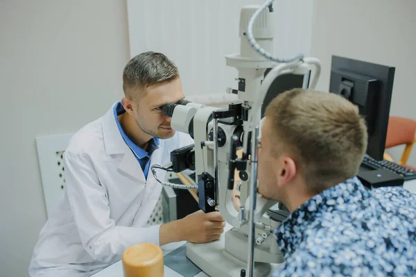 Giovane bel medico / oculista / optometrista in un oftalmo — Foto Stock