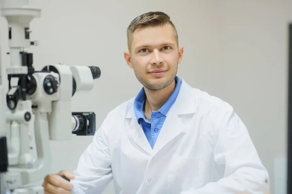 Giovane bel medico / oculista / optometrista in un oftalmo — Foto Stock