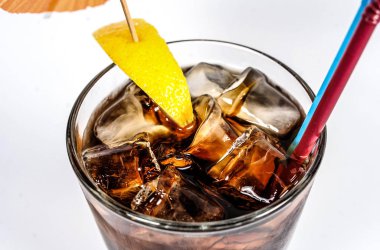 Alkollü kokteyl: ROM ve kola buz küpleri, limon ile.