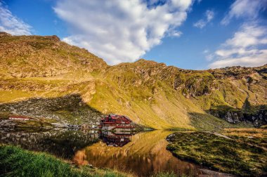 göl yakınındaki dağ eteklerinde yer alan ev