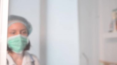 Genç bayan doktor, klinikte göğüs röntgeni radyografisini analiz ediyor.