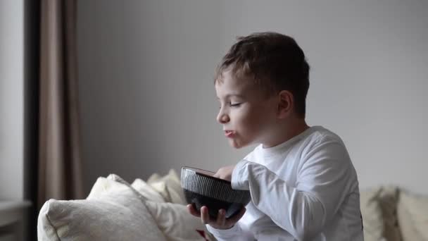 Glücklicher Junge Isst Kartoffelchips Und Lacht — Stockvideo