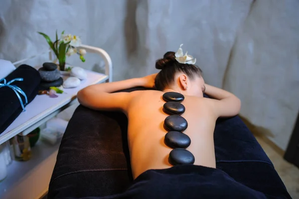 Pietra terapia su un cliente femminile in beauty spa vista laterale — Foto Stock