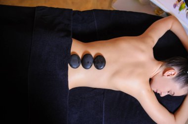 Stone therapy on a female client in beauty spa lateral view