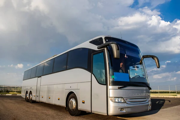 Autobus zatrzymujący się na parkingu pod błękitnym niebem z chmurami — Zdjęcie stockowe