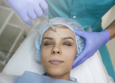 top view of elbow augmentation procedure on a young woman done by a cosmetologist doctor with Hyaluronic acid Injection.