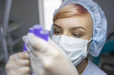 lateral view of a woman with mask looking at tubes