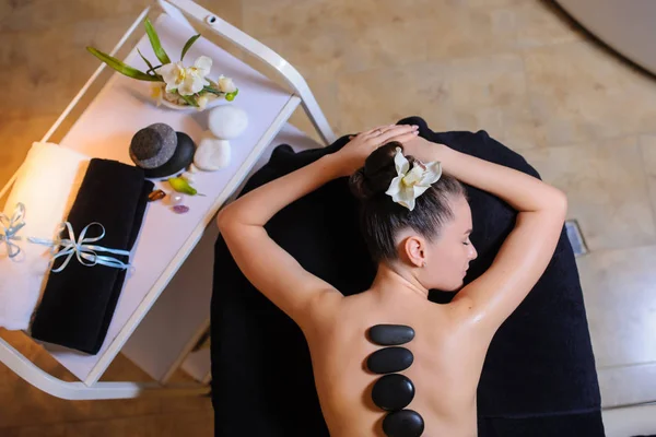Kő terápia egy női ügyfél szépség spa oldalnézetben — Stock Fotó