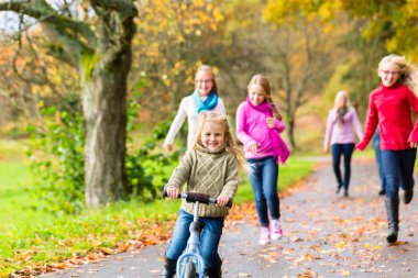 Family taking walk in autumn fall forest clipart