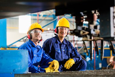 Endüstriyel metal kesme makinası fabrikasında işçi