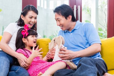 Çinli aile kızıyla kanepede oynarken