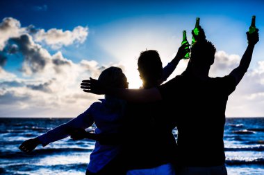 Kumsalda şişelenmiş bira içiyor arkadaşlar