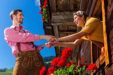 Couple in love at mountain hut window clipart