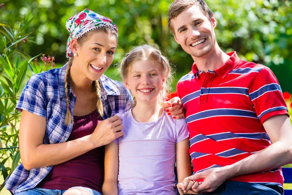 Familj i trädgården på bänk — Stockfoto