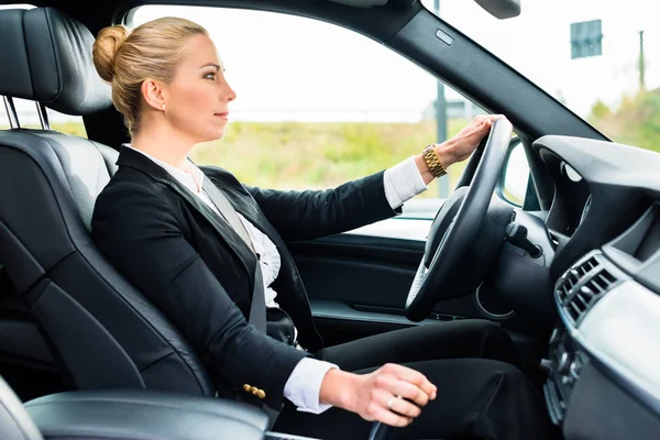 Mulher dirigindo em seu carro em trajes de negócios — Fotografia de Stock