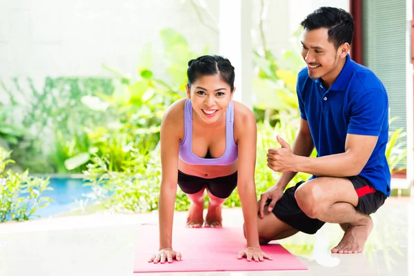 Aziatische vrouw en persoonlijke trainer bij sport oefening — Stockfoto