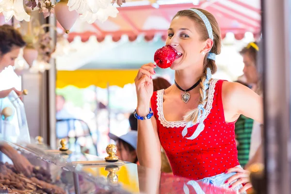 Kobieta jedzenie candy apple na Oktoberfest lub kobiece — Zdjęcie stockowe