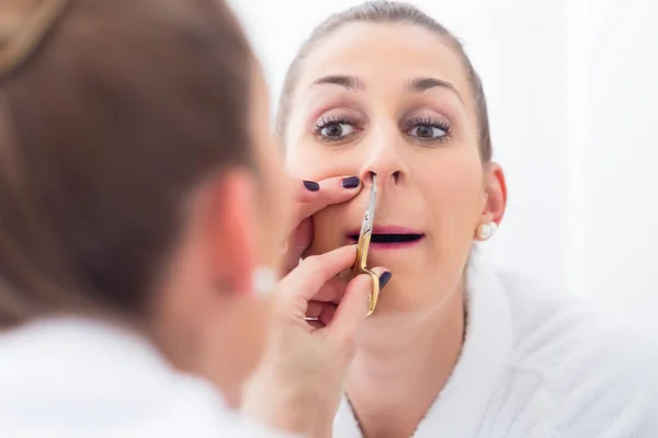 Mujer cortando su pelo de fosa nasal —  Fotos de Stock