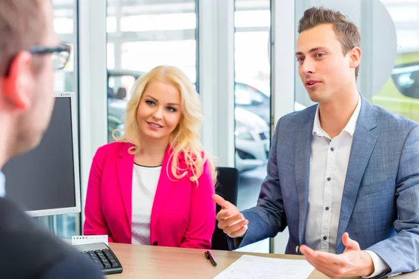 Couple negotiating sale contact for car — Stock Photo, Image