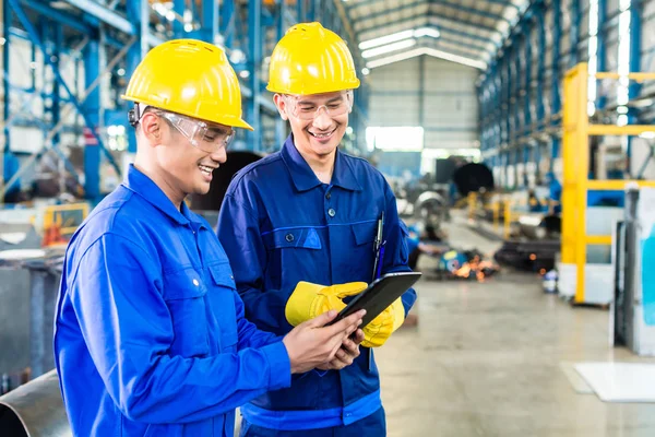 Dos trabajadores en planta de producción como equipo —  Fotos de Stock