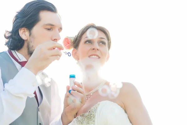 Casamento casal soprando bolhas de sabão fora — Fotografia de Stock