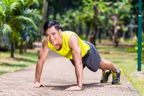 Strong Asian man doing sport push-up in park — Stock Photo, Image