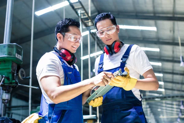 Dos trabajadores industriales inspeccionando la pieza de trabajo —  Fotos de Stock