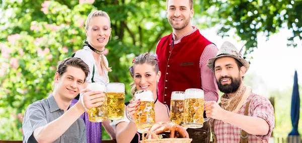 Друзів у баварський пивний сад пити влітку — стокове фото