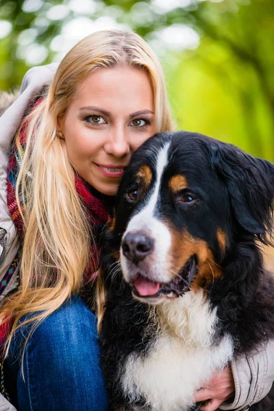 Femeie îmbrățișare cu câine de munte Bernese — Fotografie, imagine de stoc