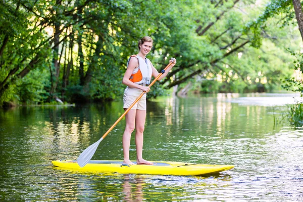 Femme pagayant avec planche de surf sup — Photo