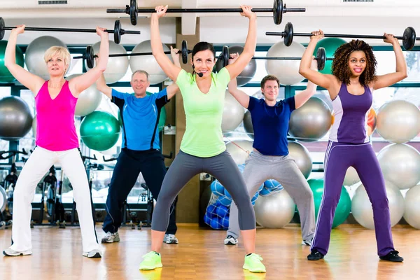 Férfiak és nők súlyzó emelésére az edzőteremben — Stock Fotó