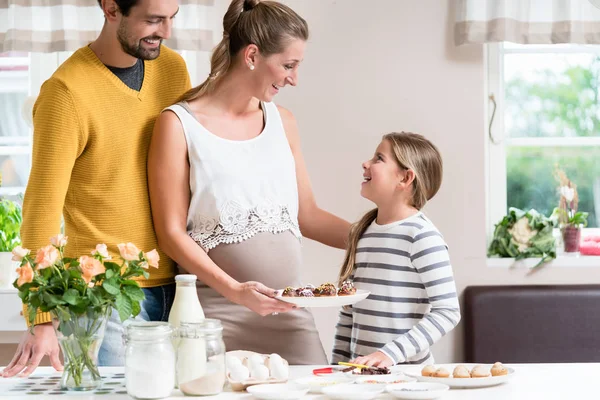 Familia con madre embarazada horneando juntos en la cocina —  Fotos de Stock