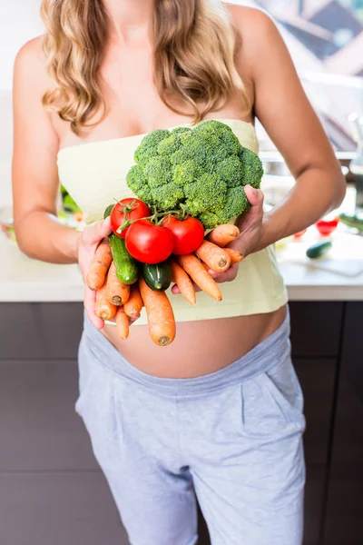 Mujer embarazada comiendo verduras saludables — Foto de Stock