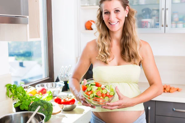 Mujer embarazada con vientre de bebé comiendo ensalada saludable —  Fotos de Stock