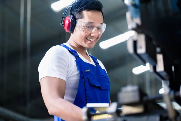 Asiatico lavoratore funzionamento metallo skip in fabbrica — Foto Stock