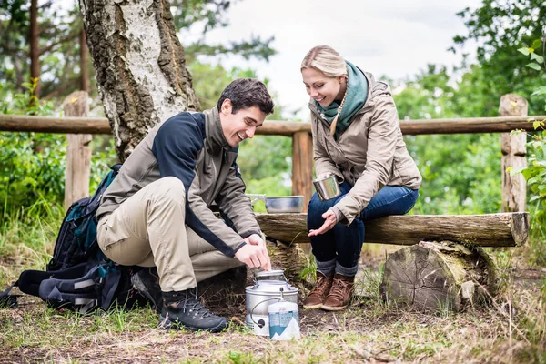 Mann und Frau machen Pause beim Wandern und Kochen — Stockfoto