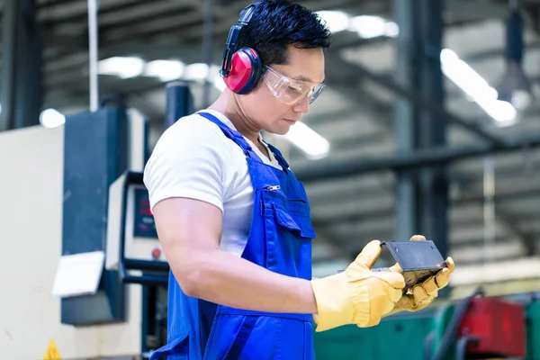 Werknemer in industriële fabriek werkstuk controleren — Stockfoto