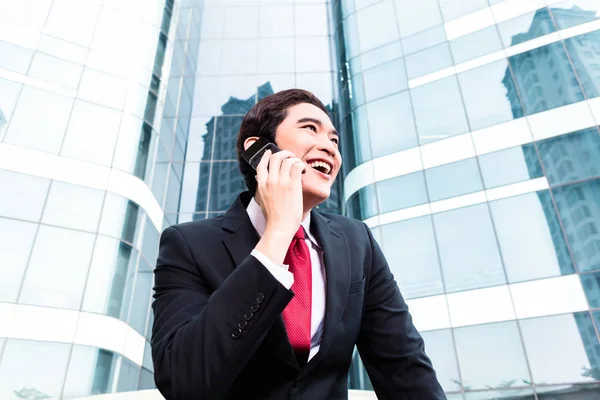 Azjatycki biznes człowiek mówi poza do telefonu komórkowego — Zdjęcie stockowe