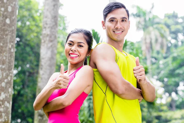 アジアの女性とトレーニングをジョギング中の男 — ストック写真