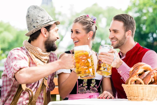 Pessoas com cerveja e pretzel na pousada da Baviera — Fotografia de Stock