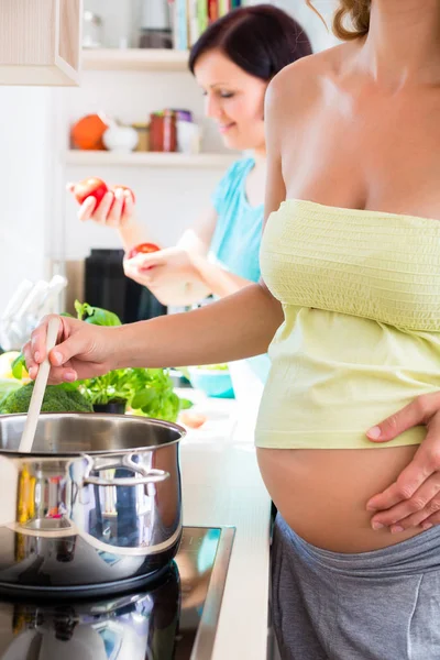 Έγκυος γυναίκα μαγείρεμα με τον καλύτερο φίλο — Φωτογραφία Αρχείου