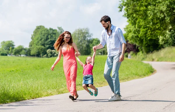 Familie lässt Kind beim Sommerspaziergang fliegen — Stockfoto