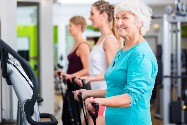 Viejos y jóvenes en placas vibratorias en el gimnasio — Foto de Stock