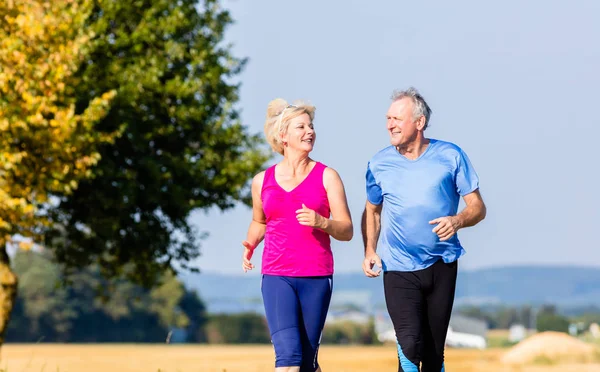 Senior vrouw en man doen fitness oefeningen — Stockfoto