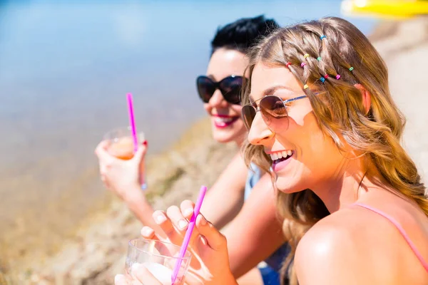 Kvinnor som dricker drinkar på stranden — Stockfoto